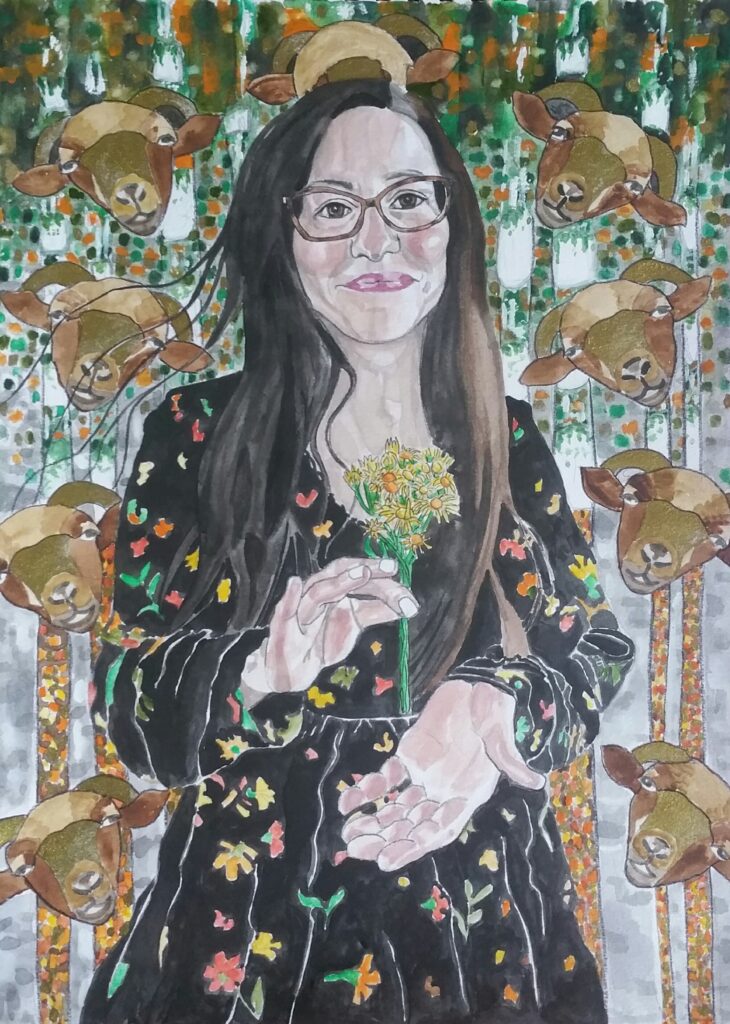 ID: Long dark haired woman wearing a black sparsley patterned dress. she is wearing glasses and is holding a bunch of ragwort flowers between finger and thumb of one hand, whilst her other hand is cupped supportively underneath. In the background are some decorative sheeps heads based on one of her pet sheep they are in shades of gold and brown and in the far background is a pattern loosely based on Klimt's painting of Birch Trees. In shades of green, orange, grey and white