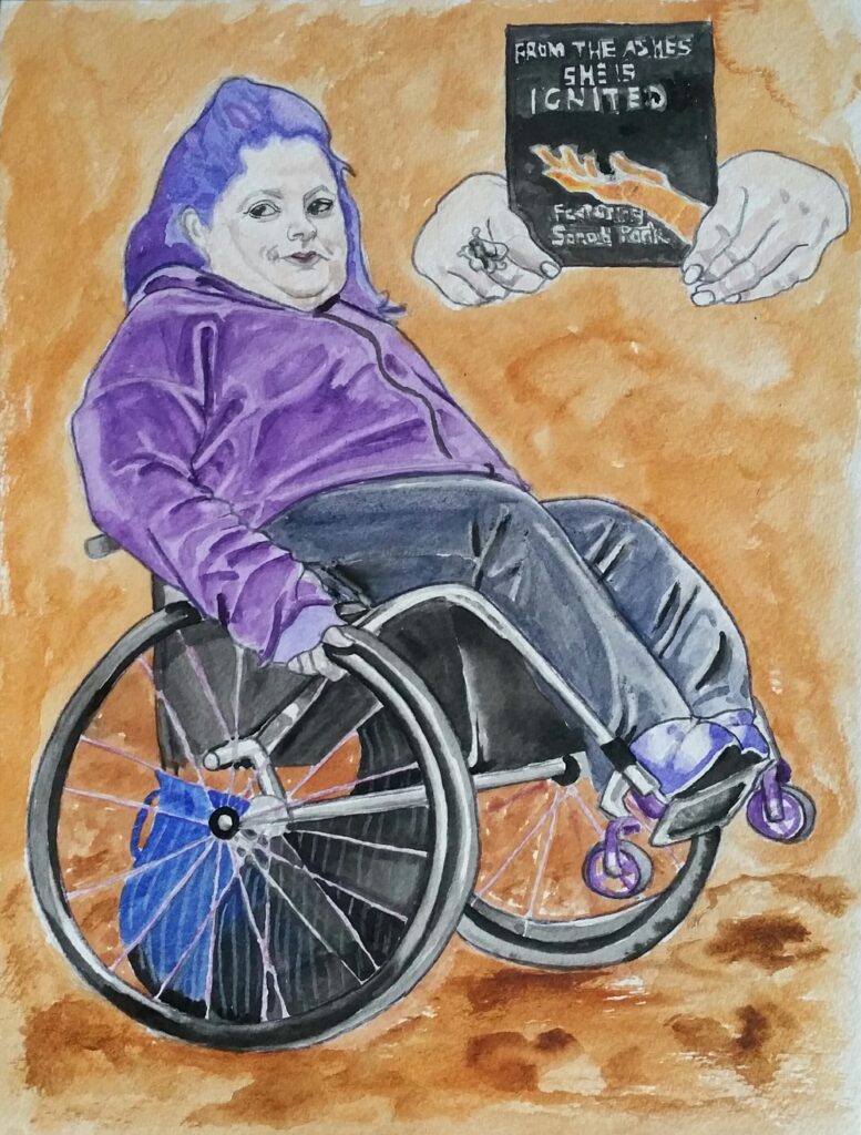 Woman with purple/blue hair, purple zip up hoodie and black/grey trousers wearing purple boots. She is sat in her wheelchair doing a wheelie. The front wheels of her wheelchair are purple as are the spokes of the big wheels. The background is autumnal orange and browns. To the top right of the picture is a book cover held by two hands which features an illustration of hand in orange flames and the title of the book is "From the Ashes she is Ignited" Underneath the illustration it says "Featuring Sarah Park"