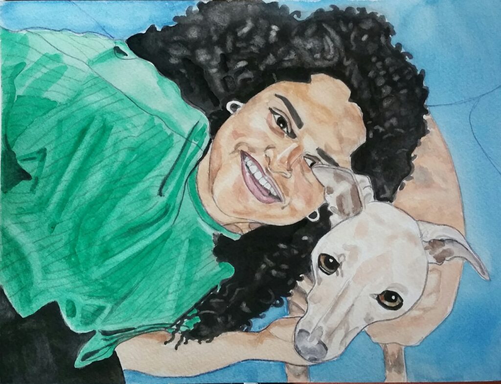 ID painting of laughing woman with fabulous big, long curly black hair, she is leaning over next to her dog whose ear is overlapping one of her eyes, the dog has a whitish head and is looking directly at us, as is Bryony. The dogs body is Mango coloured! Bryony is wearing a green top and black trousers, she is tickling her dog under the chin