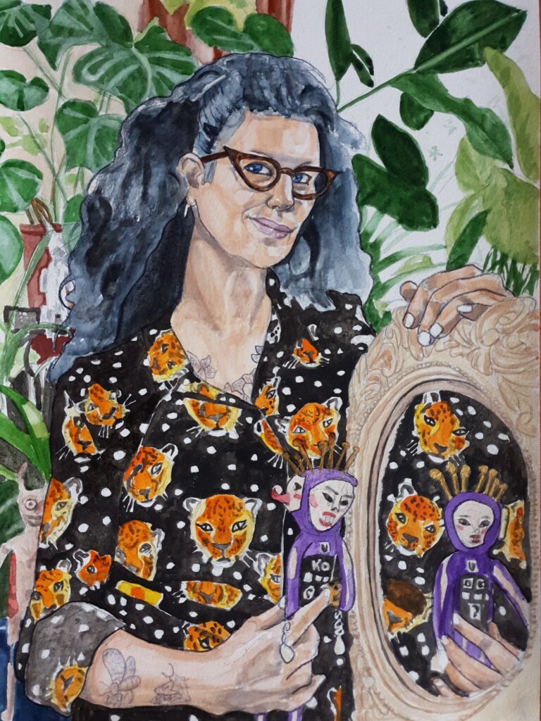 ID portrait of non-binary person, they have long thick wavy dark hair and are wearing cats eye glasses. Their top is patterned with tigers and spots. They are supporting an ornately framed mirror with one hand and in the other holding a 2 headed doll. The dolls reflection can be seen in the mirror with the shirt making a densely patterned background. Behind them in the main portrait are loads of leaves of plants and a couple of dolls sat on shelves - It is a very dense painting with a lot going on