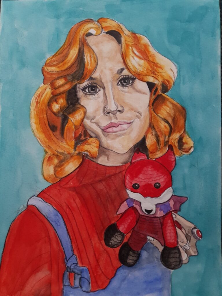ID Woman with full wavy shoulder length glorious red hair. She is wearing a red jumper and denim dungarees and holding a red knitted fox toy.