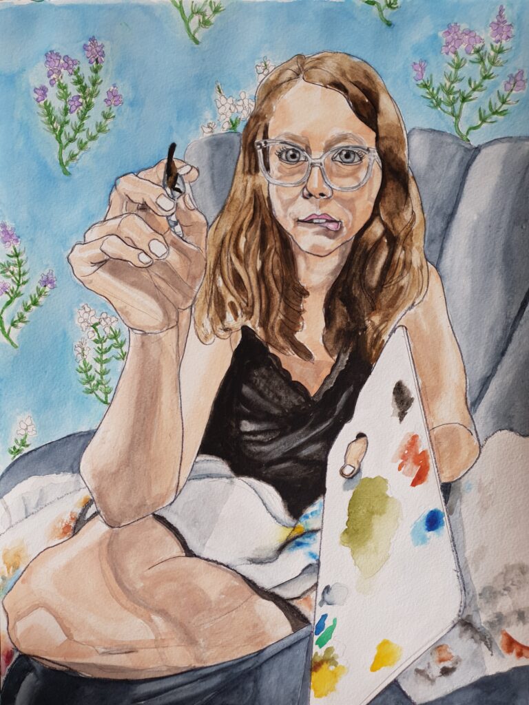 ID Portrait of woman sat with legs crossed on grey chair, she has mid brown hair and is wearing glasses and biting her lower lip. In her right hand she holds a paintbursh, arm forward, in her left a palette with some paint on it. She is wearing a black, laced neckline, sleeveless top and across her legs is a paint rag.