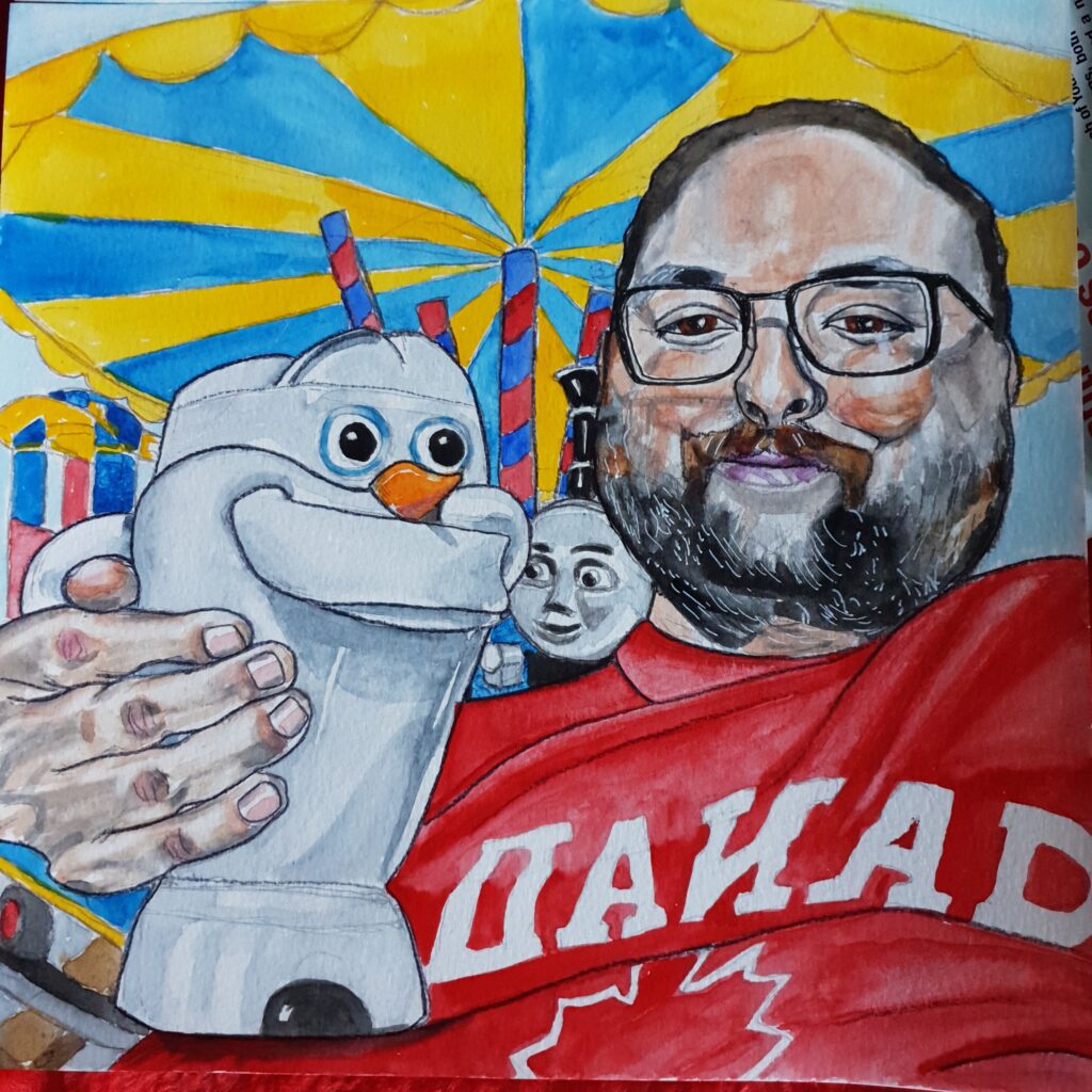 ID Man with dark eyes wearing black glasses he has dark, slightly receding hair and a ginger, black and grey beard, he is wearing a red t-shirt with Canada written on it in white and the outline of a maple leaf. In on hand he is holding a large plastic Olaf from a Disney file, which is white with an orange carrot nose. Behind him can be seen a Thomas the Tank Engine fair ride.